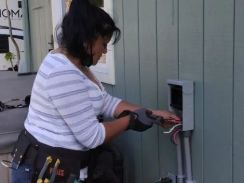 Licensed electrician wiring an exterior subpanel in Cuba